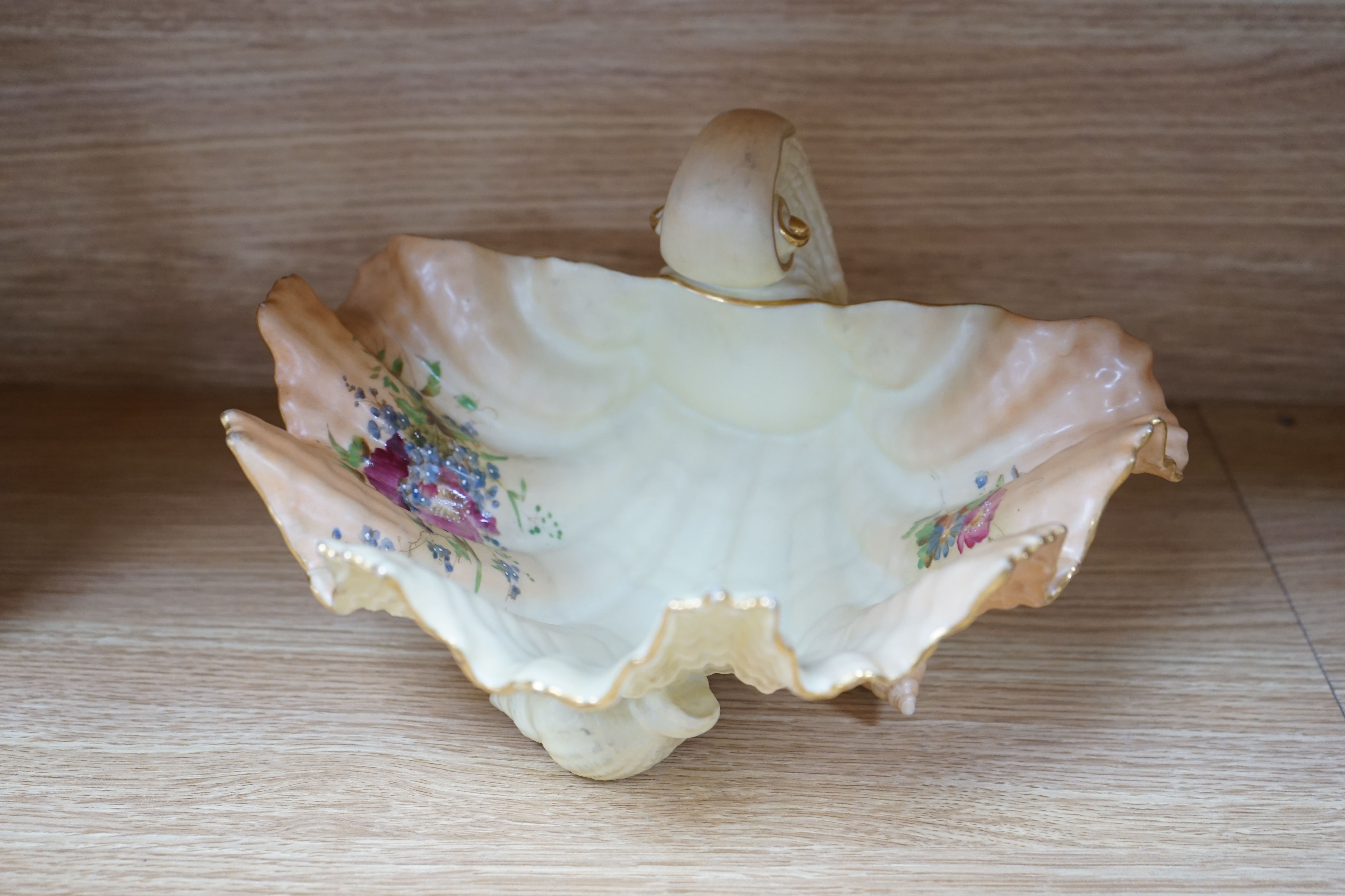 A Royal Worcester blush ivory basket, a shell dish and an ivory coloured two handled mug, 15.5cm (3). Condition - fair to good